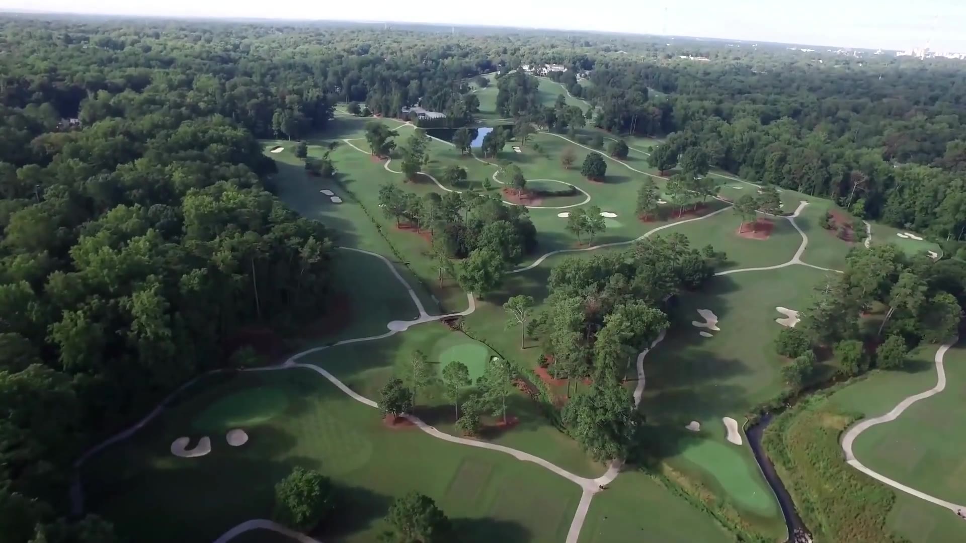 Aerial view over an Atlanta golf course and tree canopy